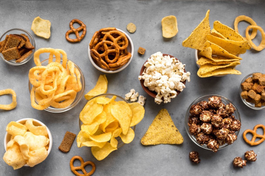 Snack foods made with resistant tapioca starch including chips, crackers, and popcorn for improved texture and fiber